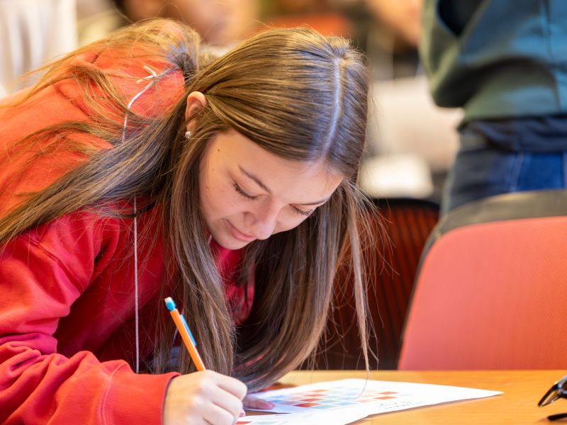 Female student writing on a paper