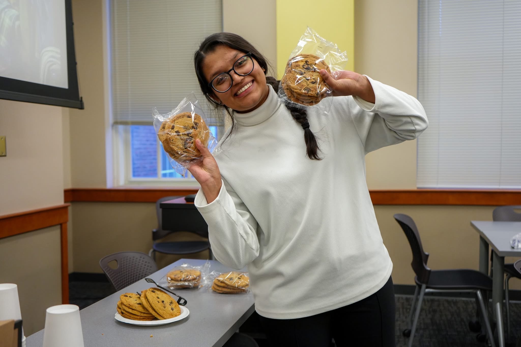 Jabika, CECH's Student Ambassador smiling holding cookies