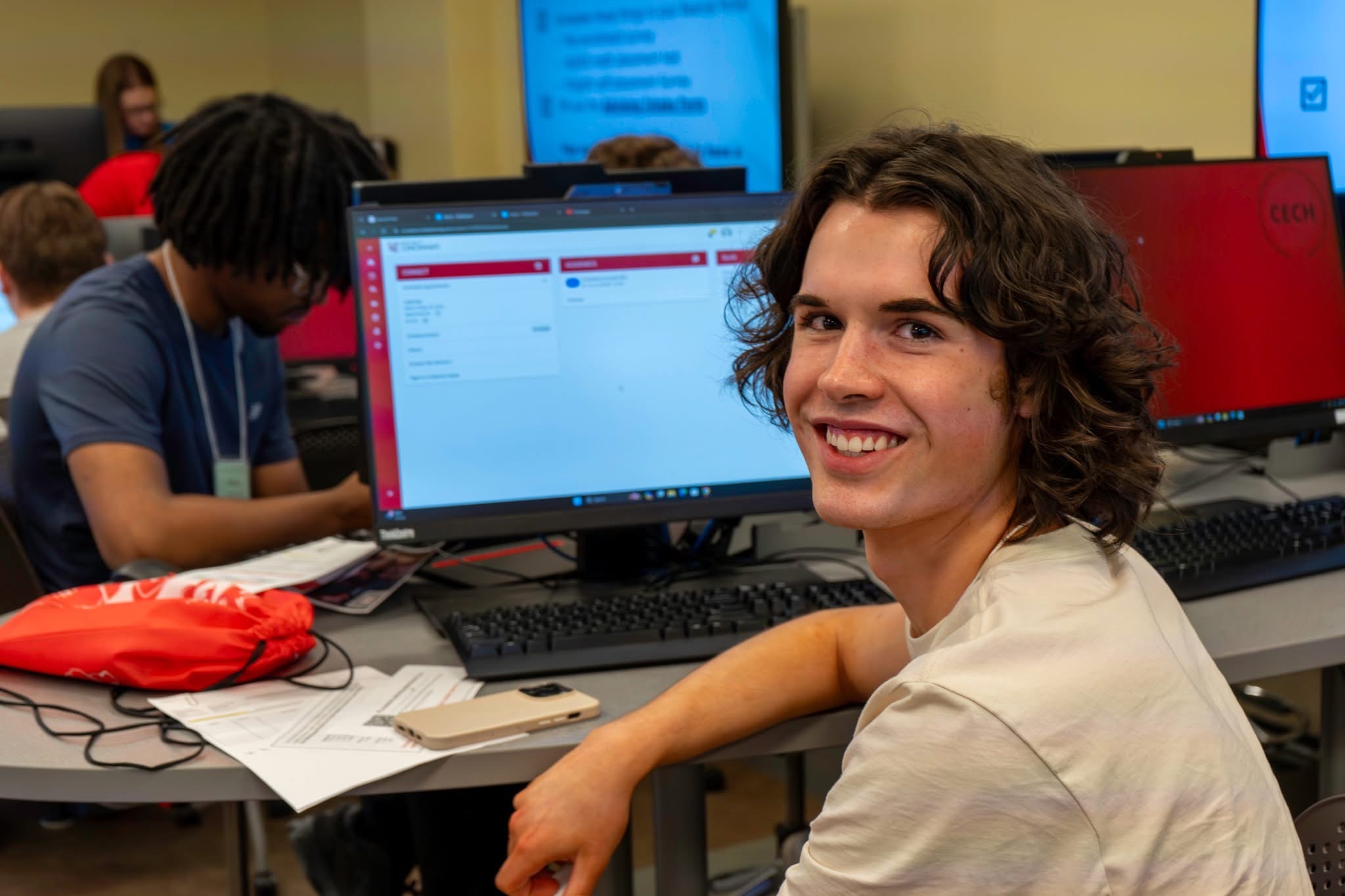 Male Caucasian student smiling in IT computer lab