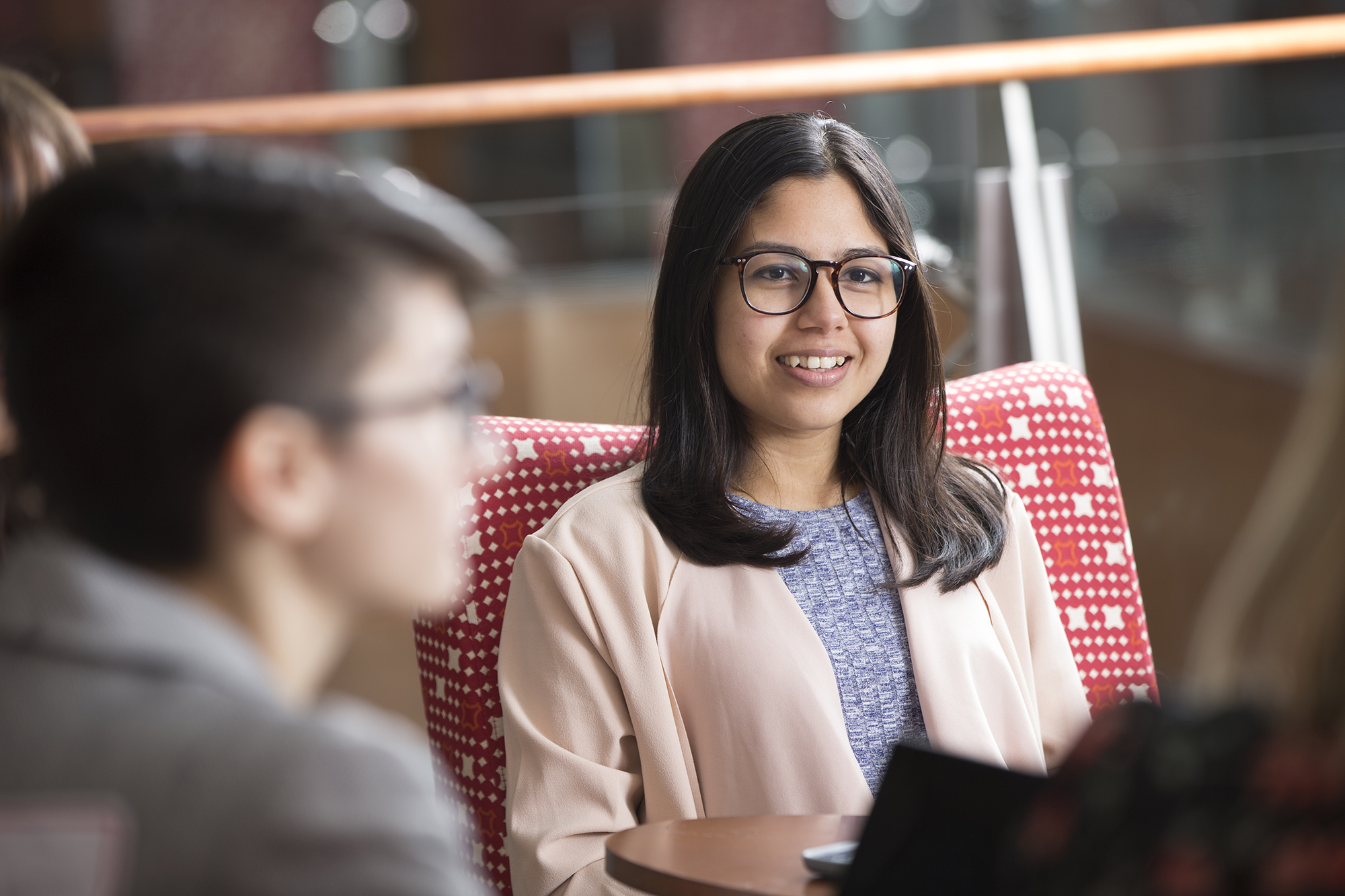 Brown female student with glasses smiling at other students