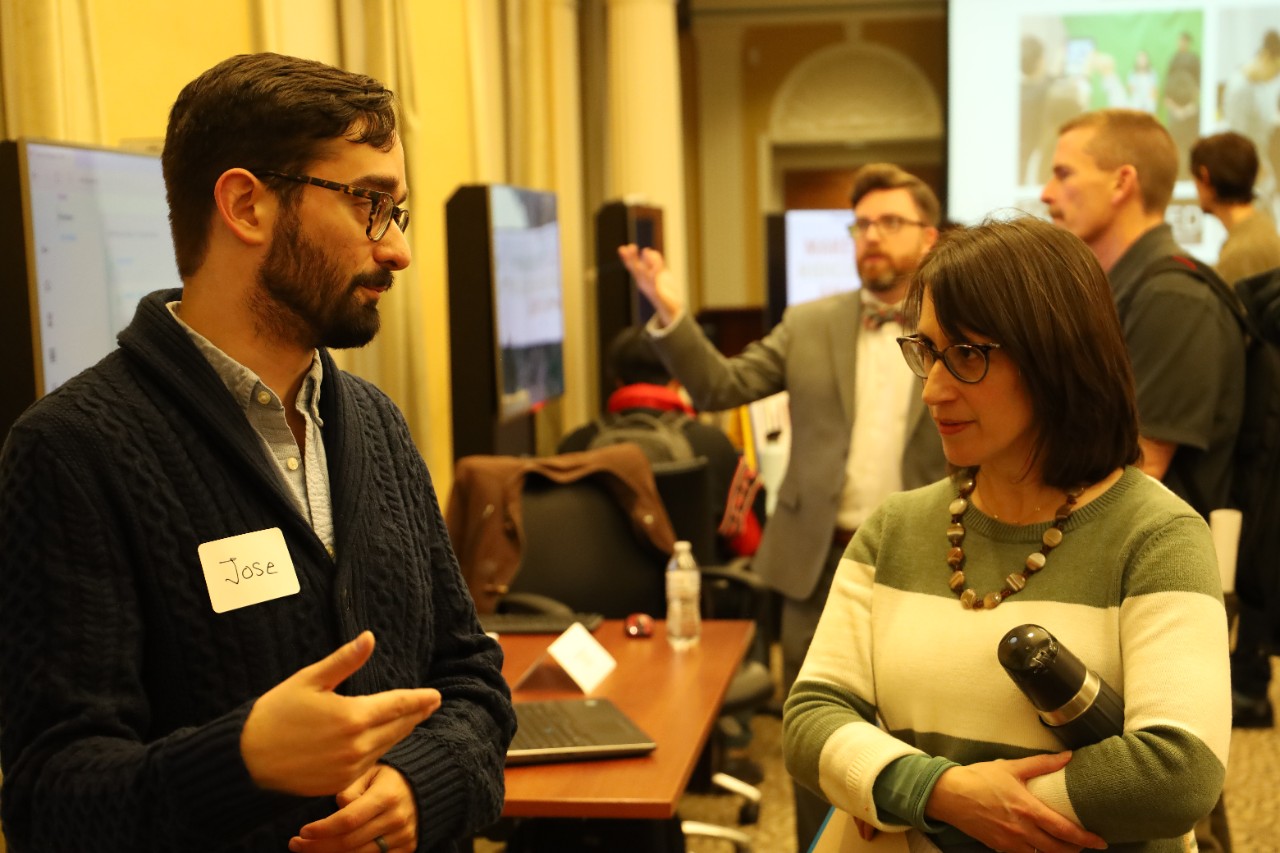 A student interacting with a faculty member at a presentation.