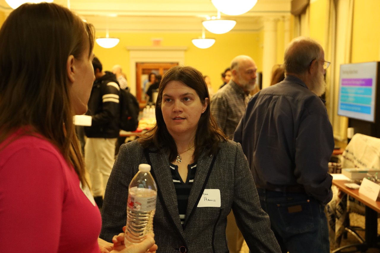 A student interacting with a faculty member at a presentation.