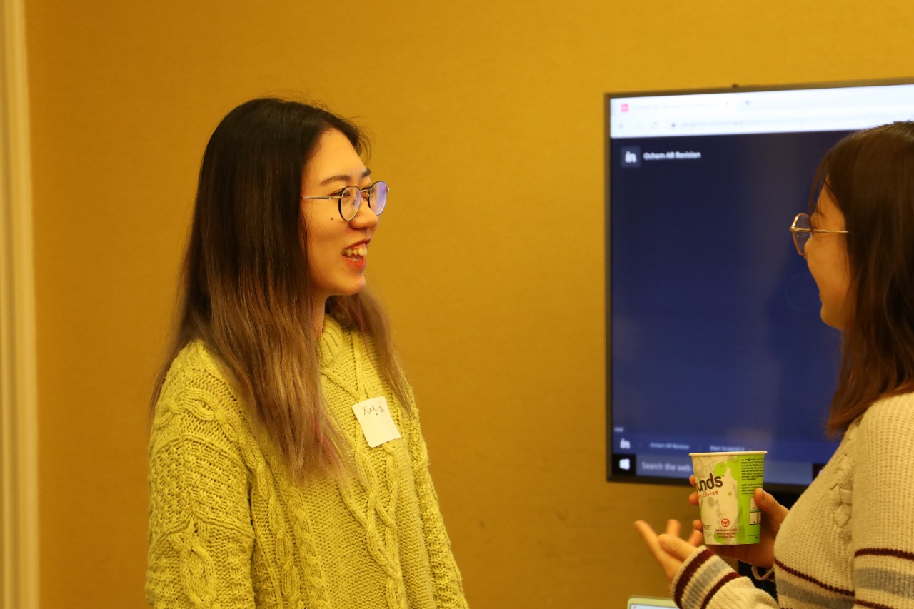 A student presenting a project to a guest at an event.