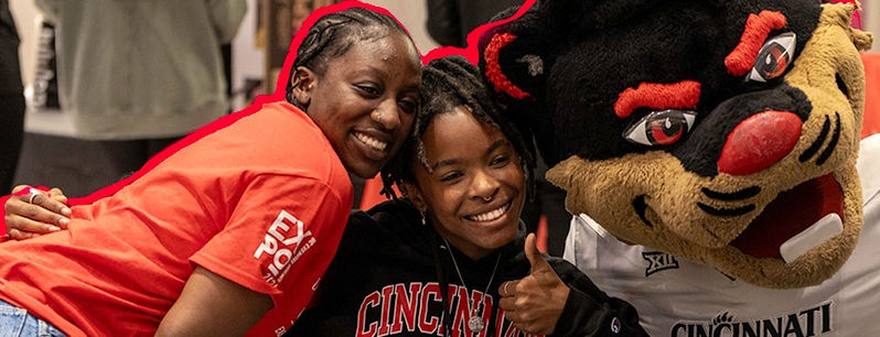  Two African American female students posing with Bearcat Mascot