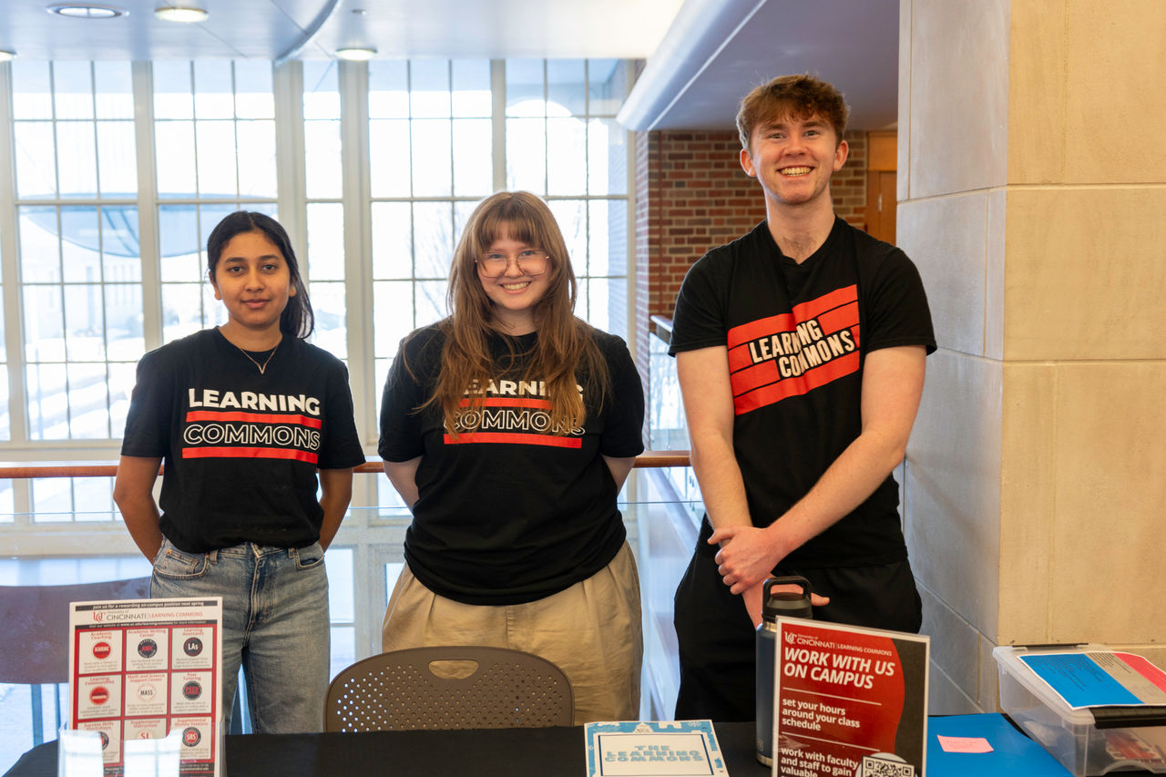 Three students posing for a photo in CECH's building