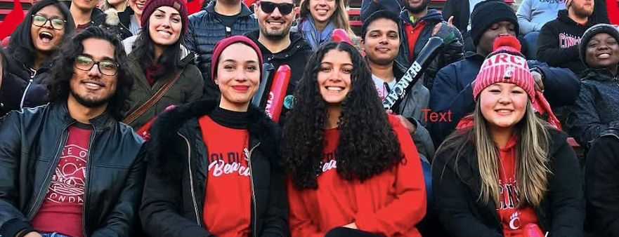 Students sitting in pews at UC stadium 